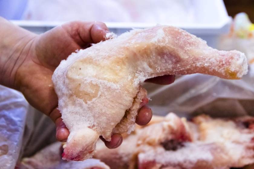 frozen chicken being held in a hand